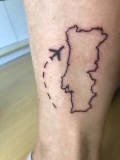 a person with a tattoo on their leg that has a map of the country and an airplane flying over it