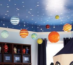 the ceiling in this child's room is decorated with planets and stars