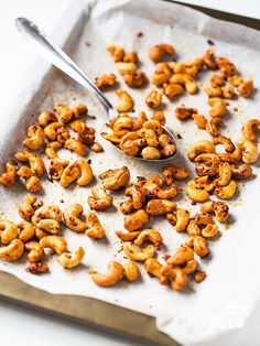 a spoon full of nuts sitting on top of a tray