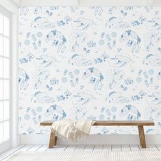 a bench sitting in front of a wallpaper with blue and white designs on it