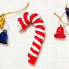 two christmas ornaments are shown on a white surface with red, white and blue yarn