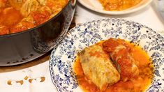 two plates with food on them next to a casserole dish filled with meat