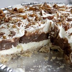 there is a chocolate pie with white frosting and nuts on top