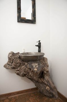 a sink that is on top of a piece of wood in a bathroom with a mirror above it