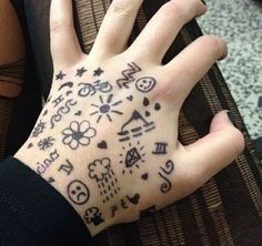 a person's hand with tattoos on it