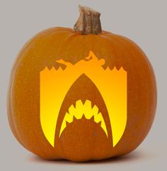 an orange pumpkin with a shark's teeth cut out of it and the shape of a mouth