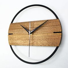 a clock made out of wood and black metal is on the wall in front of a white background