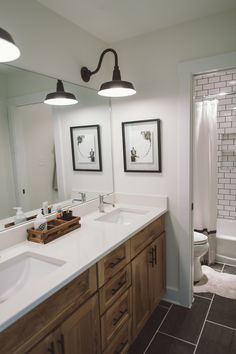 a bathroom with double sinks and two mirrors