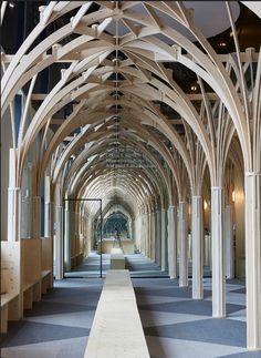 an image of a long hallway with columns and checkered flooring in the middle