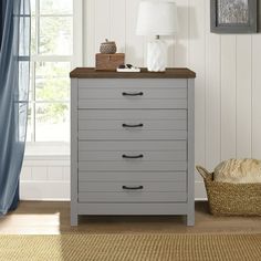 a chest of drawers in a room with blue curtains