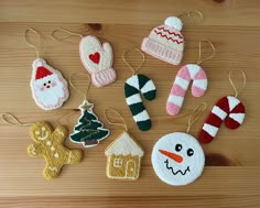 christmas ornaments are hanging on a wooden table