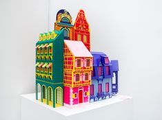 a group of brightly colored buildings sitting on top of a white shelf