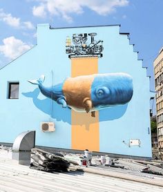 a large mural on the side of a building with a blue whale painted on it