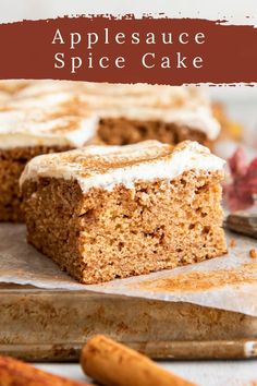 a close up of a piece of cake with frosting on top and cinnamon sticks in the background