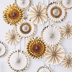 gold and white paper fans hanging on the wall