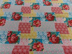 a quilted table cloth with red flowers on it