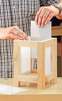 a man is making a model with wood blocks