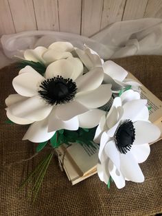 paper flowers are sitting on top of an open book