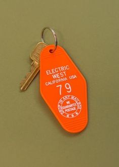 an orange keychain with the name electric west california usa written in white on it