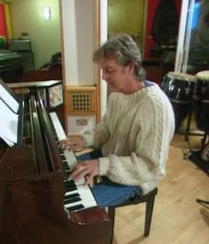 a woman sitting at a piano in a room