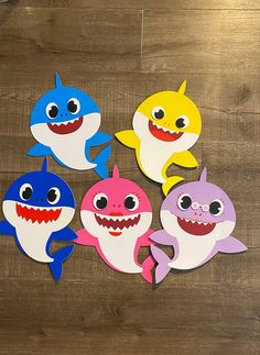 four shark cut outs sitting on top of a wooden table