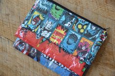 a small zippered pouch with comic characters on it sitting on top of a wooden table