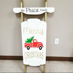 a red truck with a christmas tree on it sitting in front of a sign that says, the price family merry christmas