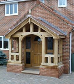 a small wooden building sitting in front of a brick building with two doors and windows