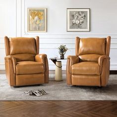 two brown leather chairs sitting next to each other on a rug in a living room