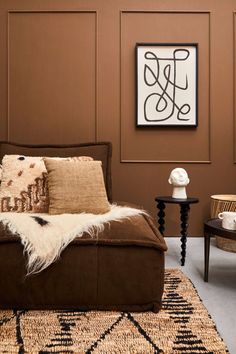 a living room with brown walls and rugs on the floor in front of it