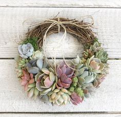 a wreath with succulents is hanging on the wall