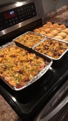 three trays of food sitting on top of an oven next to each other in pans