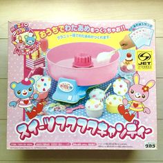 a pink toy cake making machine with cupcakes in it's box on a table