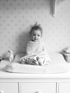 a black and white photo of a baby wrapped in a blanket