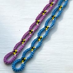 two blue and purple beaded bracelets sitting on top of each other