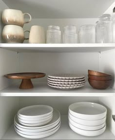 white dishes and plates on shelves in a kitchen