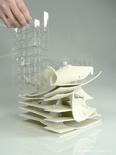 a stack of white plates stacked on top of each other in front of a person's hand