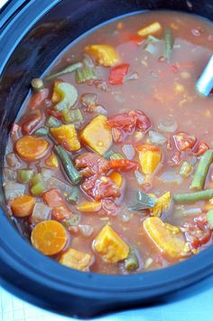 a blue crock pot filled with vegetable soup