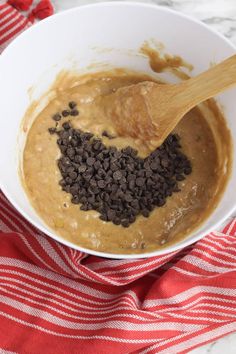 a white bowl filled with chocolate chips and peanut butter on top of a red and white towel