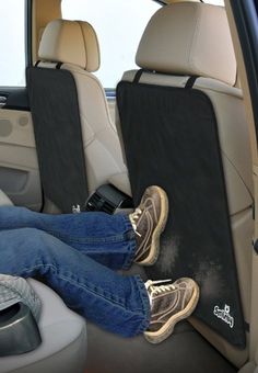 a person sitting in the back seat of a car with their feet propped up on an arm rest