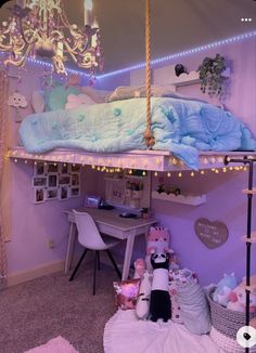 a room with a bed, desk and chair in it that has lights strung from the ceiling