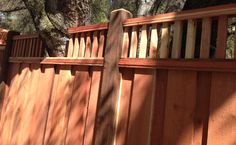 a wooden fence next to a large tree