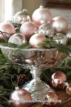 a silver bowl filled with ornaments on top of a table