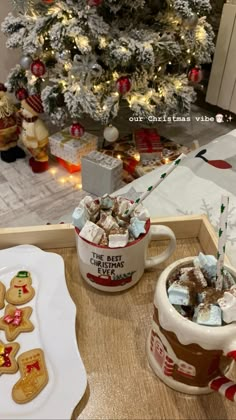 a christmas tree is in the background with cookies and other holiday treats on a tray