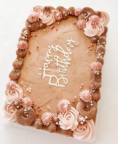 a birthday cake with pink frosting and flowers on the top that says happy birthday