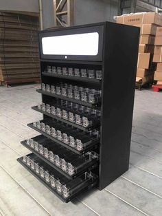 a large display case filled with lots of empty plastic cups in a warehouse floor next to stacks of cardboard boxes