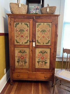 a wooden cabinet with two baskets on top of it