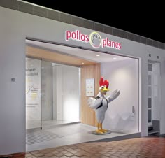 a store front with a chicken statue in the window and an advertisement for polos planes