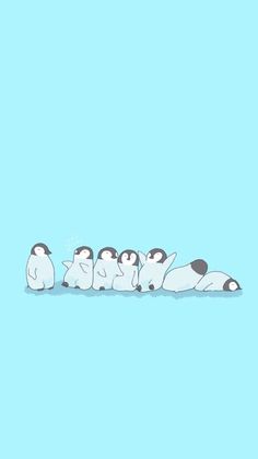 a group of penguins sitting on top of each other in the water with one penguin laying down