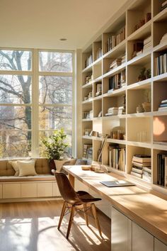 a home office with bookshelves full of books and a desk in front of a large window